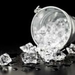 Umgekippter Eiskübel auf schwarzem Hintergrund